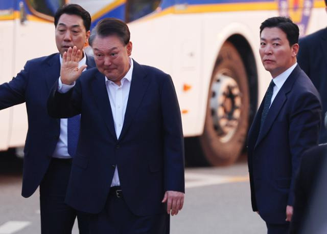 석방된 윤석열 대통령이 8일 경기 의왕시 서울구치소 앞에서 경호차량에서 내려 지지자들에게 인사하고 있다. 그 옆으로는 김성훈 경호처 차장(오른쪽)이 윤 대통령을 경호하며 이동하고 있다. 연합뉴스