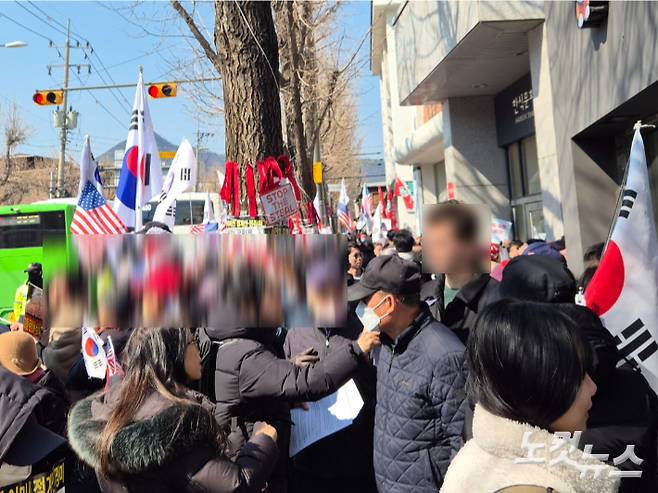 헌재 앞에서 무슨 일이 일어나고 있는지 묻는 외국인에게 영어로 설명하고 있는 윤 대통령 지지자. 나채영 기자