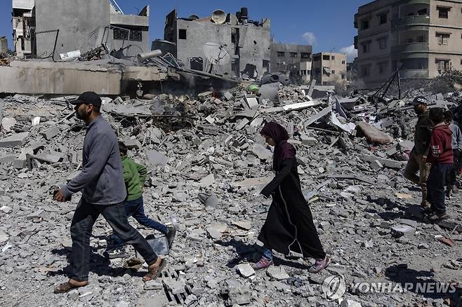 19일(현지시간) 가자지구 북부 가자시티에 대한 이스라엘 공습 후 피해 주택을 살펴보는 주민들 [EPA 연합뉴스]