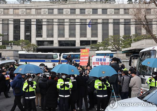 충돌 우려로 우산 펼쳐 든 경찰들 (서울=연합뉴스) 이진욱 기자 = 윤석열 대통령 탄핵심판 선고일 발표가 늦어지고 있는 가운데 20일 서울 종로구 헌법재판소 앞에서 경찰들이 탄핵 찬반 시위자들과 기자회견 참석자들 간의 충돌 등을 우려해 우산을 펼쳐 들고 있다. 2025.3.20 cityboy@yna.co.kr