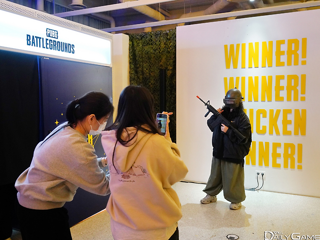 한 팬이 게임 속 장구류를 착용하고 승리 문구 앞에서 사진을 촬영했다.