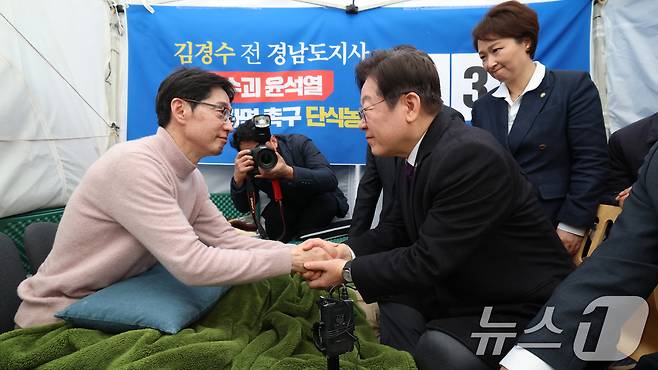 이재명 더불어민주당 대표가 21일 서울 종로구 광화문 인근에서 윤석열 대통령의 파면을 촉구하며 13일째 단식 중인 김경수 전 경남도지사의 농성장을 찾아 손을 잡고 있다. (공동취재) 2025.3.21/뉴스1 ⓒ News1 임세영 기자