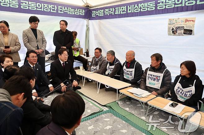 이재명 더불어민주당 대표와 지도부가 21일 서울 종로구 광화문 인근 윤석열즉각퇴진·사회대개혁 비상행동(비상행동) 단식농성장을 찾아 윤 대통령 파면을 촉구하며 14일째 단식 중인 공동의장단들을 만나 대화하고 있다. (공동취재) 2025.3.21/뉴스1 ⓒ News1 임세영 기자