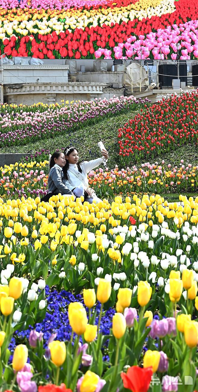 [용인=뉴시스] 김종택 기자 = 에버랜드 튤립축제가 시작된 21일 경기도 용인시 에버랜드 포시즌스 가든을 찾은 어린들이 활짝 핀 튤립을 배경으로 기념촬영을 하고 있다. 2025.03.21. jtk@newsis.com