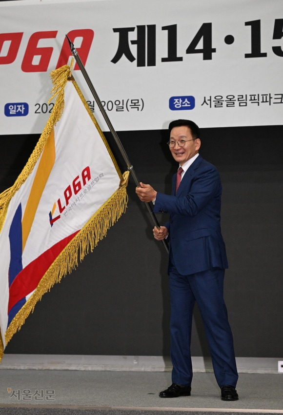 김상열 서울신문 회장이 20일 서울 송파구 올림픽파크텔에서 열린 한국여자프로골프협회(KLPGA) 15대 회장 취임식에서 전임인 14대 김정태 회장에게 건네받은 협회기를 흔들고 있다. 13대 회장을 지냈던 김 회장은 4년 만에 한국 여자골프의 수장으로 복귀했다. 도준석 전문기자