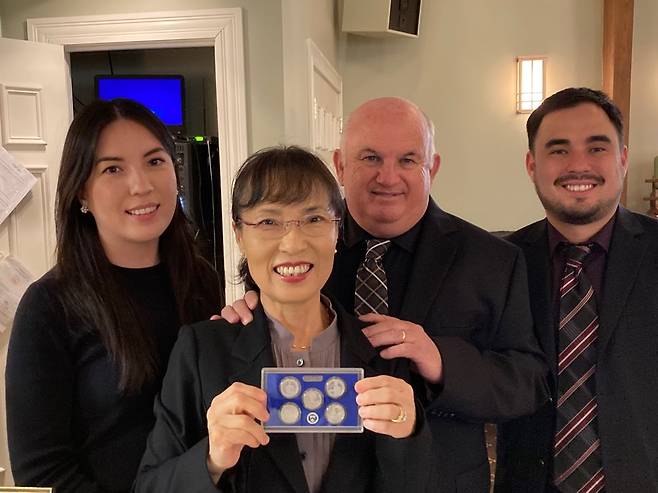 /스테이시 밀번 가족 제공스테이시 박 밀번의 가족들이 고인의 얼굴이 새겨진 25센트 동전 기념세트를 받고 미소짓고 있다. 왼쪽부터 여동생 제시카, 어머니 진, 아버지 조엘, 남동생 데이비드.