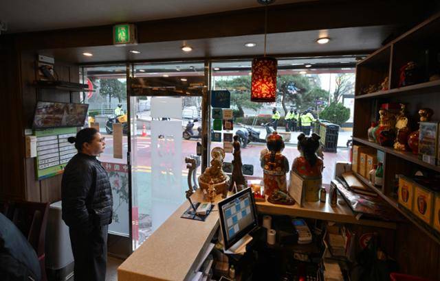 13일 서울 명동 중국대사관 인근에서 자교모의 반중 집회가 열리는 가운데 중식당 직원이 밖을 내다보고 있다. 최주연 기자