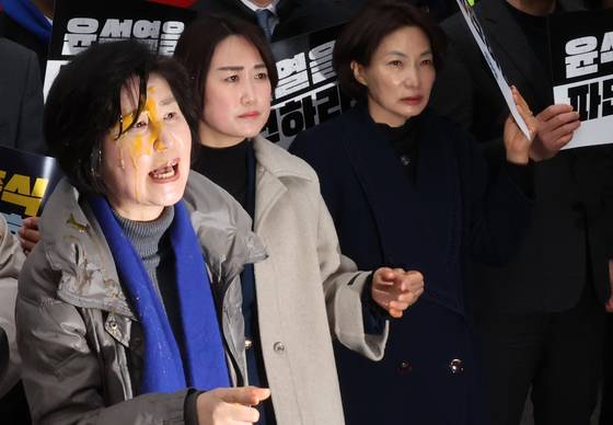 더불어민주당 백혜련 의원이 20일 서울 종로구 헌법재판소 앞에서 열린 윤석열 대통령 신속 파면 촉구 기자회견에서 한 보수단체 회원이 던진 계란으로 얼굴을 맞은 뒤 항의하는 모습. 연합뉴스