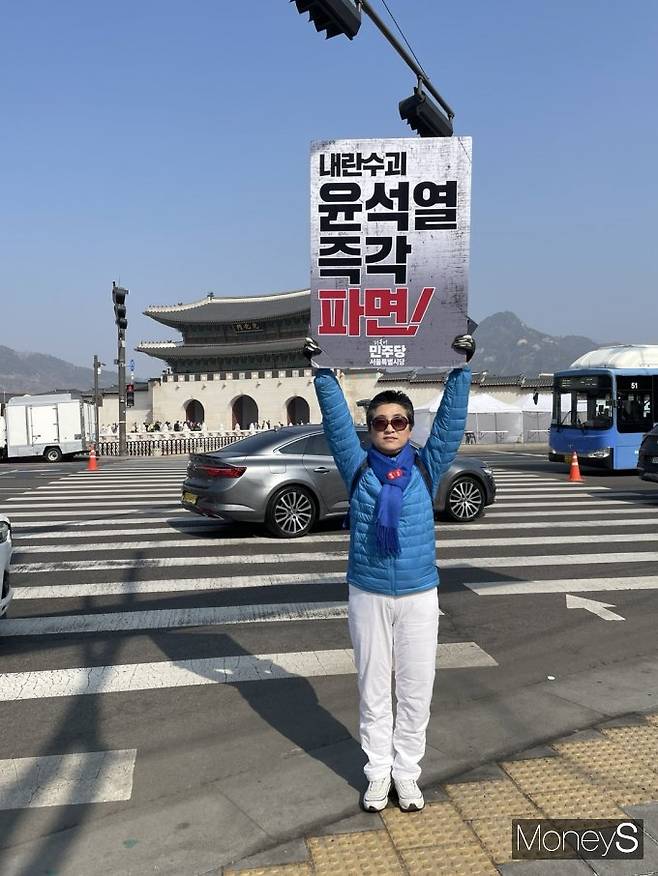 서울시의회 문화체육관광위원회 소속 유정희 시의원(서울 관악구)이 광화문문 앞 횡단보도에서 ‘내란수괴 윤석열 즉각 파면!’이라는 문구가 적힌 피켓을 들고 서있다. /사진=이소연 기자