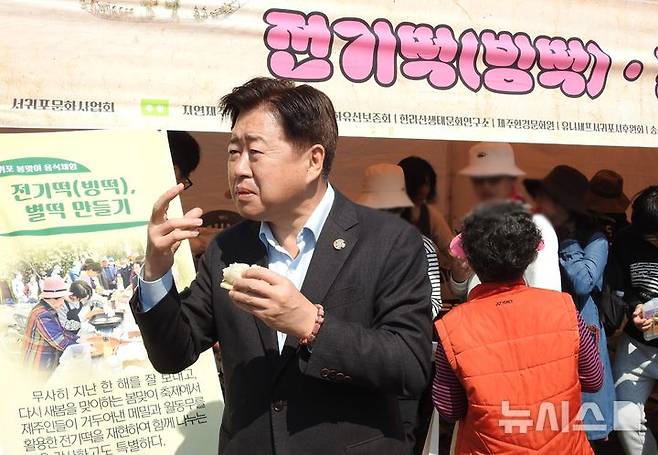 [제주=뉴시스] 오영재 기자 = 오영훈 제주지사가 22일 오전 제주 서귀포시 동홍동 서복공원에서 열린 제14회 서귀포 봄맞이 축제에서 전기떡을 시식하고 있다. 전기떡은 메밀과 월동무를 활용해 만든 제주 토속음식이다. 2025.03.22. oyj4343@newsis.com