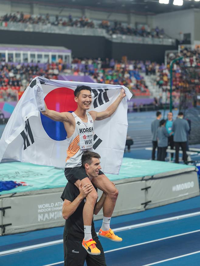 우상혁을 목말 태우며 축하하는 커. 사진 | 대한육상연맹