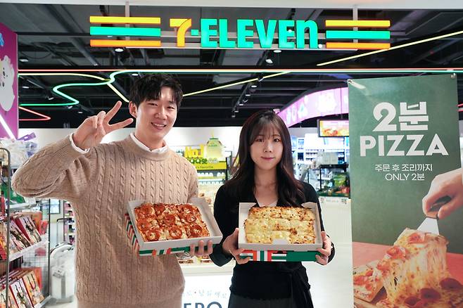 모델이 세븐일레븐 '2분피자'를 소개하고 있다.