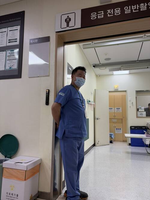 병원에서 환자의 발이 되어주는 이송반 베테랑 이운회씨가 환자 이송을 한 뒤 촬영실 앞에 서서 활짝 웃고 있다. 남궁인 제공