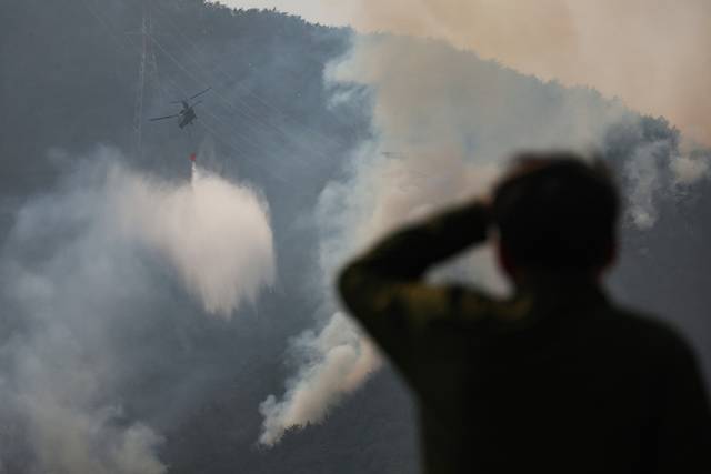 ▲ 경남 산청군에서 발생한 산불 사흘째인 23일 단성면 일대에 산불이 마을 쪽으로 향하자 헬기가 물을 뿌리며 산불을 진압하고 있다. 연합뉴스