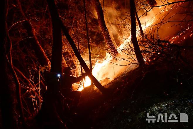 [산청=뉴시스] 차용현 기자 = 22일 오후 전날 경남 산청에서 발생한 산불이 산등성이를 타고 확산되고 있는 가운데 산림청 소속 공중진화대가 산불을 진화하고 있다. 2025.03.22. con@newsis.com