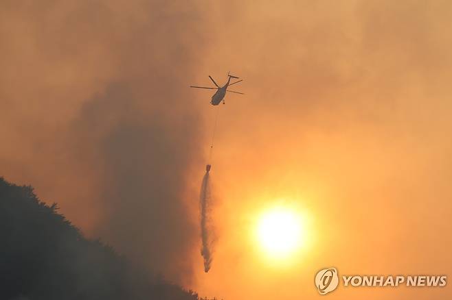 산불과의 사투 (산청=연합뉴스) 손형주 기자 = 경남 산청군에서 발생한 산불 사흘째인 23일 헬기가 야산에 물을 뿌리며 산불을 진압하고 있다. 2025.3.23 handbrother@yna.co.kr