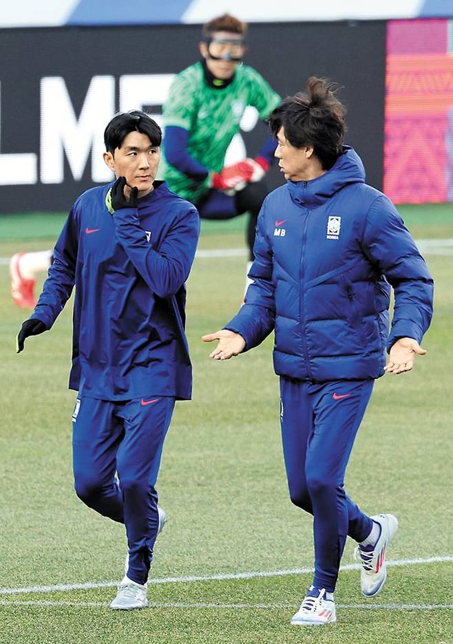 홍명보(오른쪽) 축구 대표팀 감독이 지난 19일 오만전을 앞둔 훈련 중 미드필더 황인범과 대화하고 있다. 이강인, 백승호 등 중원 자원이 부상으로 이탈한 탓에 오는 25일 요르단전에서는 황인범의 역할이 중요해졌다. /뉴스1