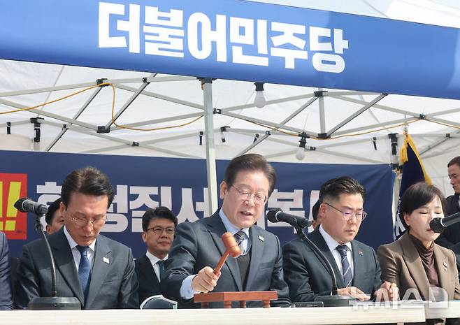 [서울=뉴시스] 김명년 기자 = 이재명 더불어민주당 대표가 24일 서울 종로구 광화문 천막당사에서 열린 최고위원회의에 참석해 개회봉을 치고 있다. (공동취재) 2025.03.24. kmn@newsis.com