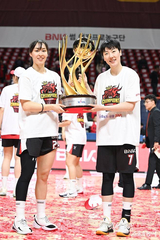 BNK 박혜진(오른쪽)이 20일 사직체육관에서 열린 우리은행과 챔피언 결정전 3차전에서 승리한 뒤 김소니아와 챔피언 트로피를 들고 환하게 웃고 있다. 사진제공｜WKBL