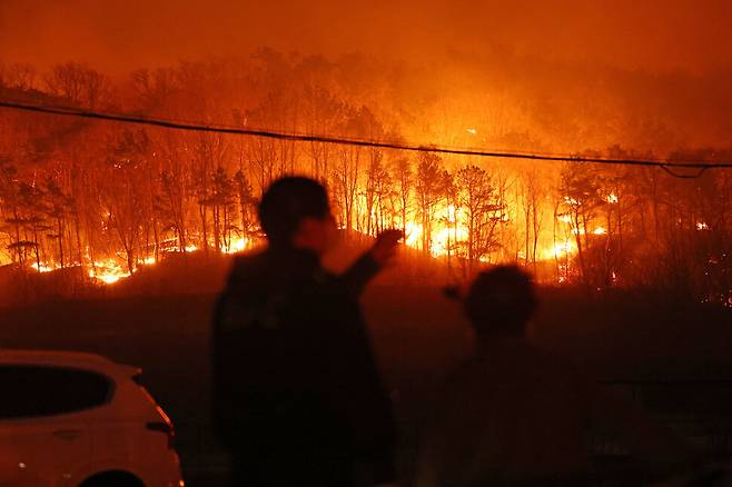 25일 경북 안동시 남선면 마을에서 주민들이 야산에 번진 산불을 바라보고 있다. 연합뉴스