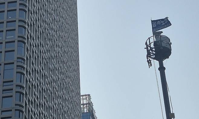 ‘한화’라고 적혀있는 서울 중구 한화 본사 옆 CCTV 관제탑에 ‘금속노조’ 깃발이 휘날리고 있다. 저 깃발 옆에 김형수 거제·통영·고성 조선하청지회장이 있다. 신다은 기자