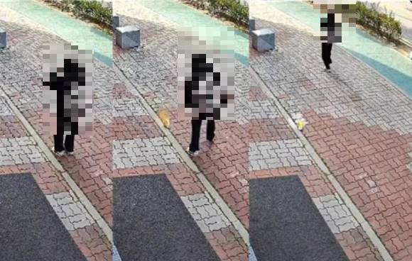 길을 걷다 먹던 컵라면을 바닥에 버리고 가는 학생이 CCTV에 찍혔다. [사진=온라인 커뮤니티]