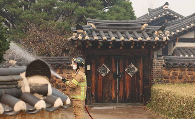 ▲ 26일 경북 안동 하회마을에서 소방대원이 산불 불씨가 옮겨 붙지 않도록 마을 곳곳에 물을 뿌리고 있다. 연합뉴스