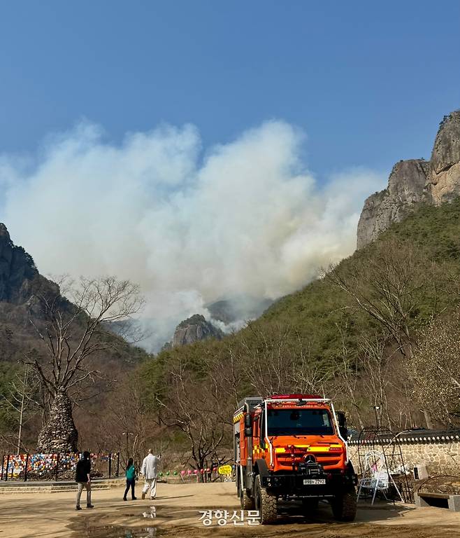 26일 오후 3시15분쯤 경북 청송군 주왕산의 장군봉(왼쪽)과 기암단애(오른쪽) 사이의 골짜기에서 연기가 피어오르고 있다. 이날 오후 들어 바람이 거세지면서 약 2시간 전보다 불이 확산한 모양새다. 백경열 기자