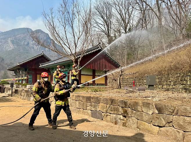 소방대원들이 26일 오후 대전사 인근에 불이 번질 것을 대비해 소방수를 뿌리고 있다. 백경열 기자