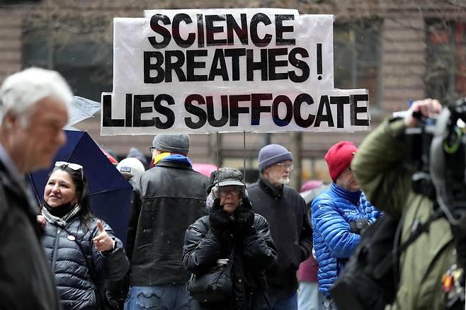 A woman holds a sign at the Stand Up for Science rally to protest the Trump administration's science policies and federal job cuts on March 7, in Chicago. [AP/YONHAP]