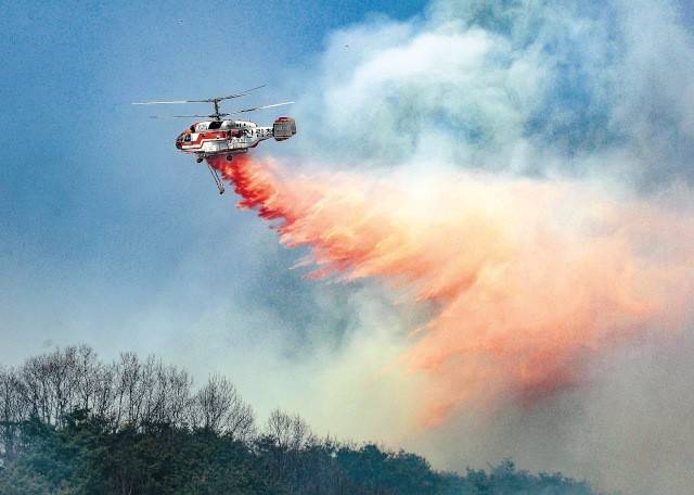 산림청 헬기가 지난 24일 경북 의성군 옥산면 정자리 야산에 산불지연제를 투하하고 있다. 사흘째 이어진 의성군 산불은 강풍과 건조한 날씨 등으로 인근 안동시까지 번졌다. 이미 경남 산청군 산불은 전날 인근 하동군으로까지 옮겨 붙었다. 연합뉴스