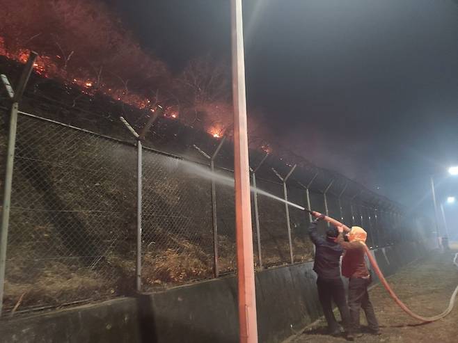 지난 25일 경북 청송군 경북북부 제2교도소에서 교도소 인근까지 번진 산불을 막기 위해 직원들이 물을 뿌리고 있다. [법무부 교정본부 제공]