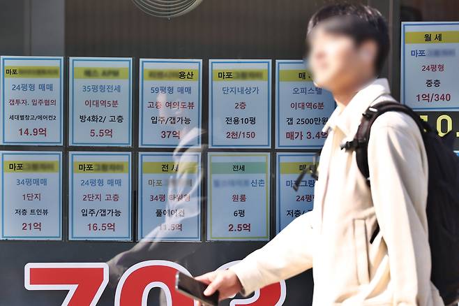 사진은 서울 시내 한 부동산 중개업소 앞을 시민이 지나는 모습.  [연합]