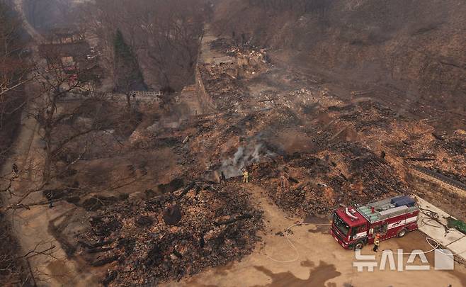 [의성=뉴시스] 김금보 기자 = 26일 대형 산불로 전소 피해를 입은 경북 의성군 단촌면 고운사에서 소방대원들이 진화작업을 하고 있다. 이번 산불로 고운사 보물인 연수전과 가운루를 비롯해 연지암, 해우소, 정묵당, 아거각, 약사전, 연수전, 고운대암, 극락전, 만덕당, 종무소가 불탔다. 2025.03.26. kgb@newsis.com