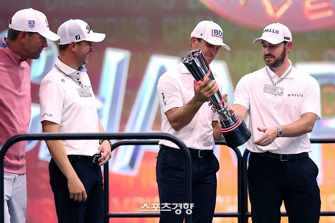 빌리 호셜(오른쪽 두 번째)이 26일 미국 플로리다주 팜비치 가든스의 소파이센터에서 열린 TGL 챔피언 결정전 2차전에서 애틀랜타 GC의 우승을 이끈 뒤 시상대에서 트로피를 패트릭 캔틀레이(오른쪽)에게 건네주고 있다. 왼쪽은 루카스 글로버와 저스틴 토머스. ｜TGL 홈페이지