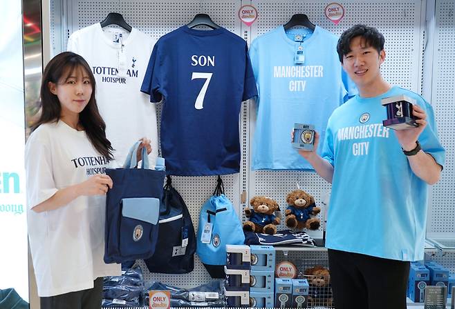 모델이 세븐일레븐에서 판매하는 EPL 인기구단 토트넘, 맨시티의 패션아이템을 소개하고 있다.