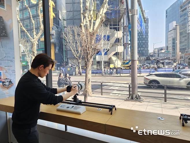 고객이 소니코리아 압구정점에서 망원렌즈로 창문 밖을 촬영하고 있다. (사진=김신영 기자)