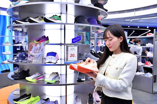 롯데백화점 부산본점 5층 나이키에서 직원이 고객에게 러닝화를 보여주고 있다. 롯데백화점은 4월 4일부터 13일까지 봄철 러닝을 즐기는 고객들을 위한 '러너스 위크'를 진행한다. 롯데백화점 제공