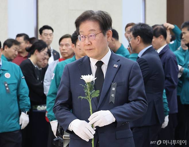 [의성=뉴시스] 김금보 기자 = 이재명 더불어민주당 대표가 27일 경북 의성군 의성군청소년문화의집에 마련된 '의성 산불 진화헬기 추락'으로 순직한 고 박현우 기장의 빈소를 찾아 헌화하고 있다. 2025.03.27. kgb@newsis.com /사진=김금보