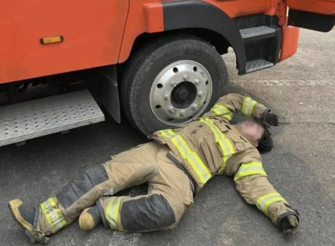 지친 소방대원이 바닥에 누워 잠시 휴식을 취하고 있다. 사진=SNS 갈무리