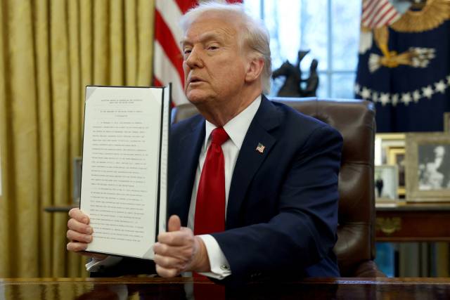 도널드 트럼프 미국 대통령이 26일(현지 시간) 워싱턴DC 백악관 집무실에서 수입 자동차에 25%의 관세를 부과하는 내용의 명령문에 서명한 뒤 이를 들어보이고 있다. 로이터연합뉴스