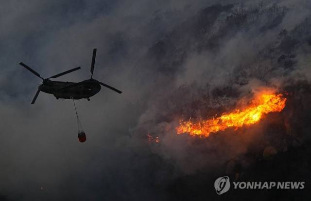 일본 자위대 헬리콥터가 지난 25일 혼슈 서부 오카야마현 오카야마시에서 산불 진화 활동을 하고 있다. 연합뉴스