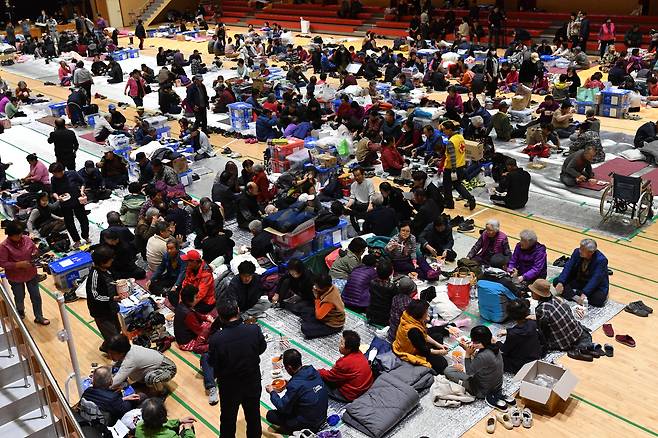 27일 오후 경북 영덕군 영덕읍 영덕국민체육센터에서 지품면 등 산불 피해 이재민들이 대한적십자사 등 자원 봉사자들이 준비한 식사를 하고 있다./뉴스1