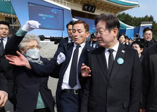 이재명 더불어민주당 대표가 28일 국립대전현충원에서 제10회 서해수호의날 기념식 참석 후 퇴장하던 중, 북한군에 의한 천안함 피격으로 순직한 고(故) 민평기 상사의 어머니 윤청자 여사로 추정되는 유족으로부터 항의를 받고 있다.<연합뉴스 사진>