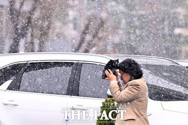 전국 대부분 지역의 아침 기온이 떨어진 가운데, 29일 오전 눈이 내리는 서울 도봉구 일대에서 한 시민이 가방으로 눈을 피하며 이동하고 있다.