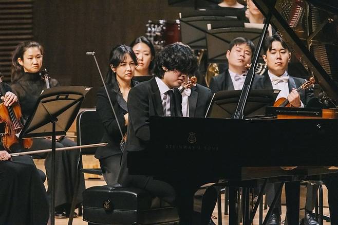 피아니스트 임윤찬이 지난 28일 경남 통영시 통영국제음악당에서 열린 통영국제음악제 개막 공연에서 통영페스티벌오케스트라(지휘 파비앵 가벨)와 협연하고 있다. 통영국제음악재단 제공