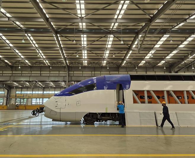 지난 27일 경기 고양시 수도권철도차량정비단 중정비동 내에서 도색 작업을 마친 KTX 열차 동력차량을 코레일 관계자들이 살펴보고 있다. 김동환 기자