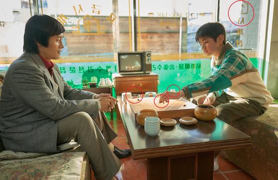 영화 '승부'의 장면. 조훈현이 이창호의 기력을 테스트하는 장면이다. 사진 오른쪽 위에 이창호 아버지가 운영했던 '이시계점' 글씨가 보인다. 이창호는 왼손잡이다. 처음에는 왼손으로 바둑을 뒀다. 바둑판 너머로 재떨이와 이창호가 좋아했던 '바나나맛우유'가 살짝 보인다. 사진 바이포엠스튜디오