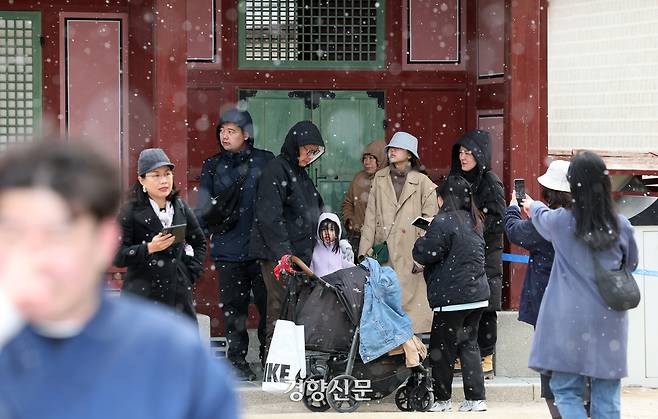 꽃샘추위와 함께 눈이 내린 30일 오전 서울 종로구 경복궁에서 관람객들이 처마 밑에서 눈을 피하며 수문장 임명의식을 지켜보고 있다. 2025.03.30.정지윤 선임기자