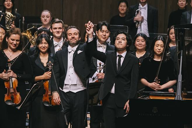 French conductor Fabien Gabel (front left) and South Korean pianist Lim Yunchan (front right) greet the audience after the opening concert of the Tongyeong International Music Festival at the Tongyeong Concert Hall in Tongyeong, South Gyeongsang Province, Friday. (TIMF)